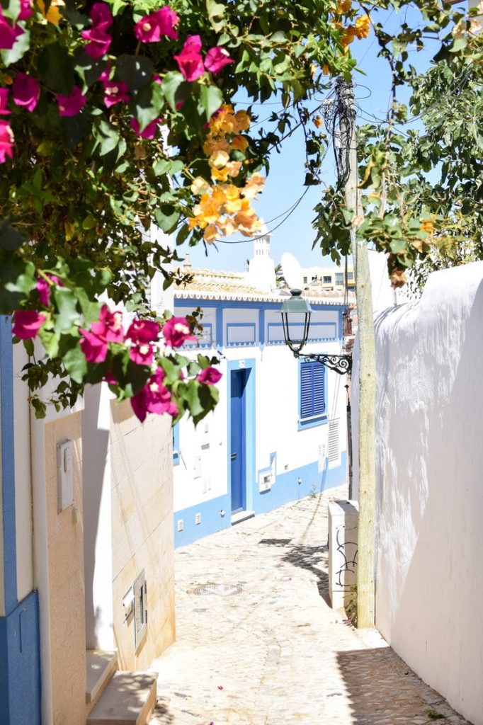 Backstreets of Ferragudo fishing town with bougainvillea, Algarve, Portugal
